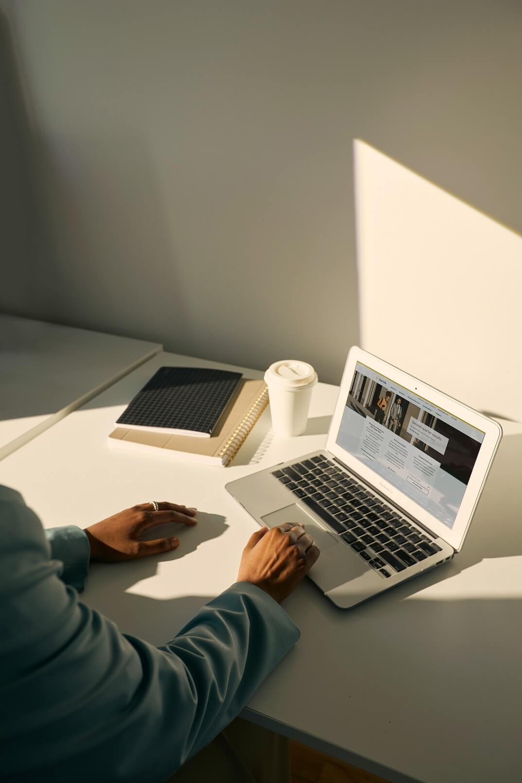 Personne assise à un bureau et travaille sur son ordinateur portable.